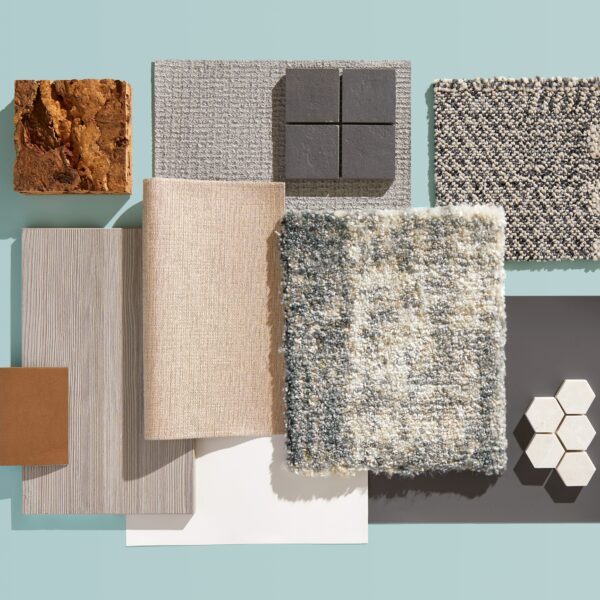 Flatlay of neutral materials highlighting the idea of refined contrast in shades of gray, beige, and brown on a soft blue background.