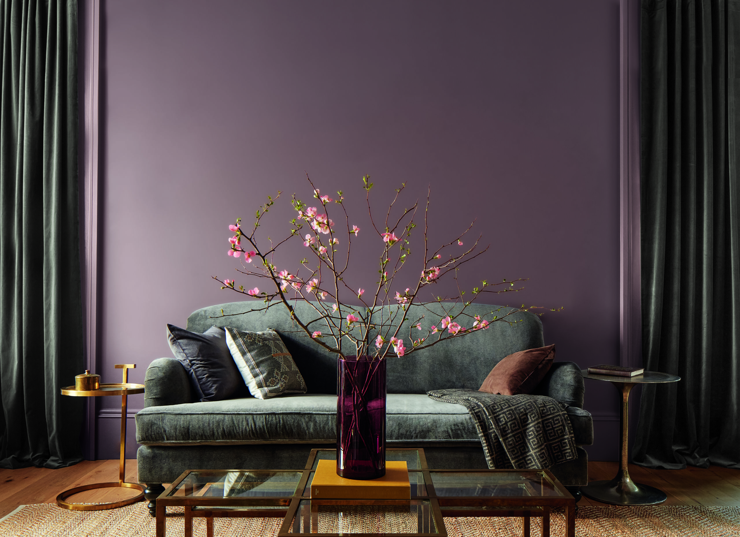 Benjamin Moore Color of the Year 2025 Cinnamon Slate 2113-40 paint shown on the wall of a living room with a couch, coffee table and vase sitting in the middle in front of the wall.