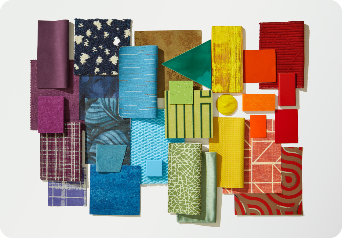 An image showcasing a celebration of color. A flat lay with a variety of material samples ranging from tiles and textiles to wallcoverings and surfaces creating a gradient effect in shades of red, orange, yellow, green, blue, indigo and violet.