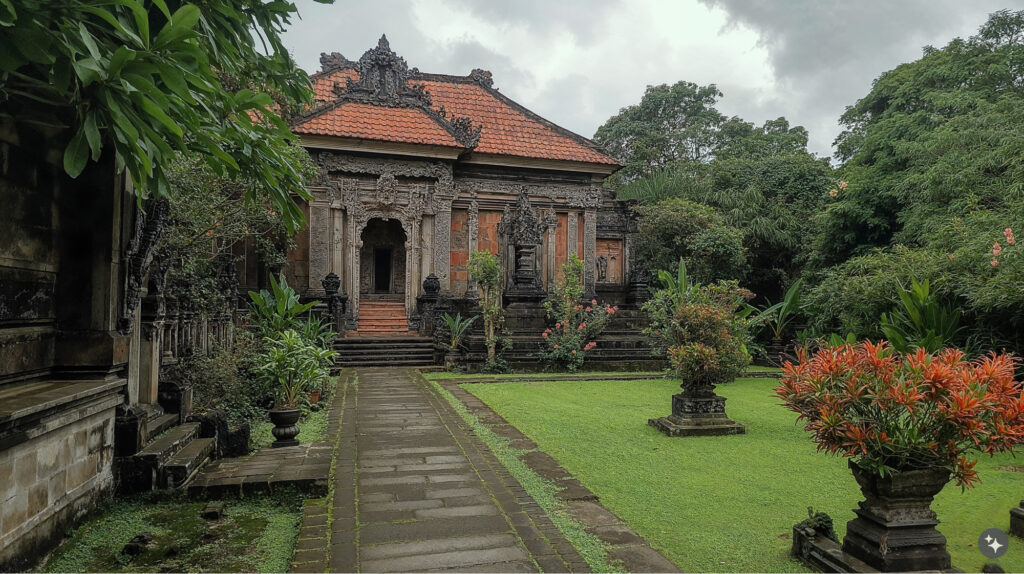 Balinese design Puri (palace) exterior with stone pathway surrounding large green lawns. Stone steps lead up to a Puri with intricately carved exterior facade and trim. 