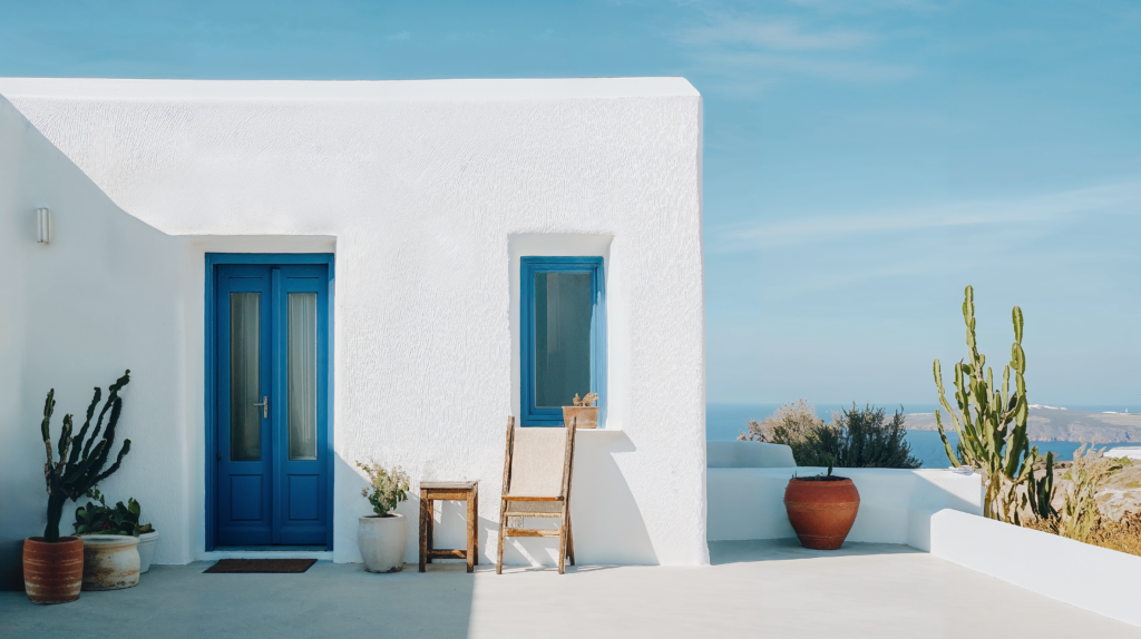 Greek Island design in a residential exterior overlooking the water, white stone, and blue accents.