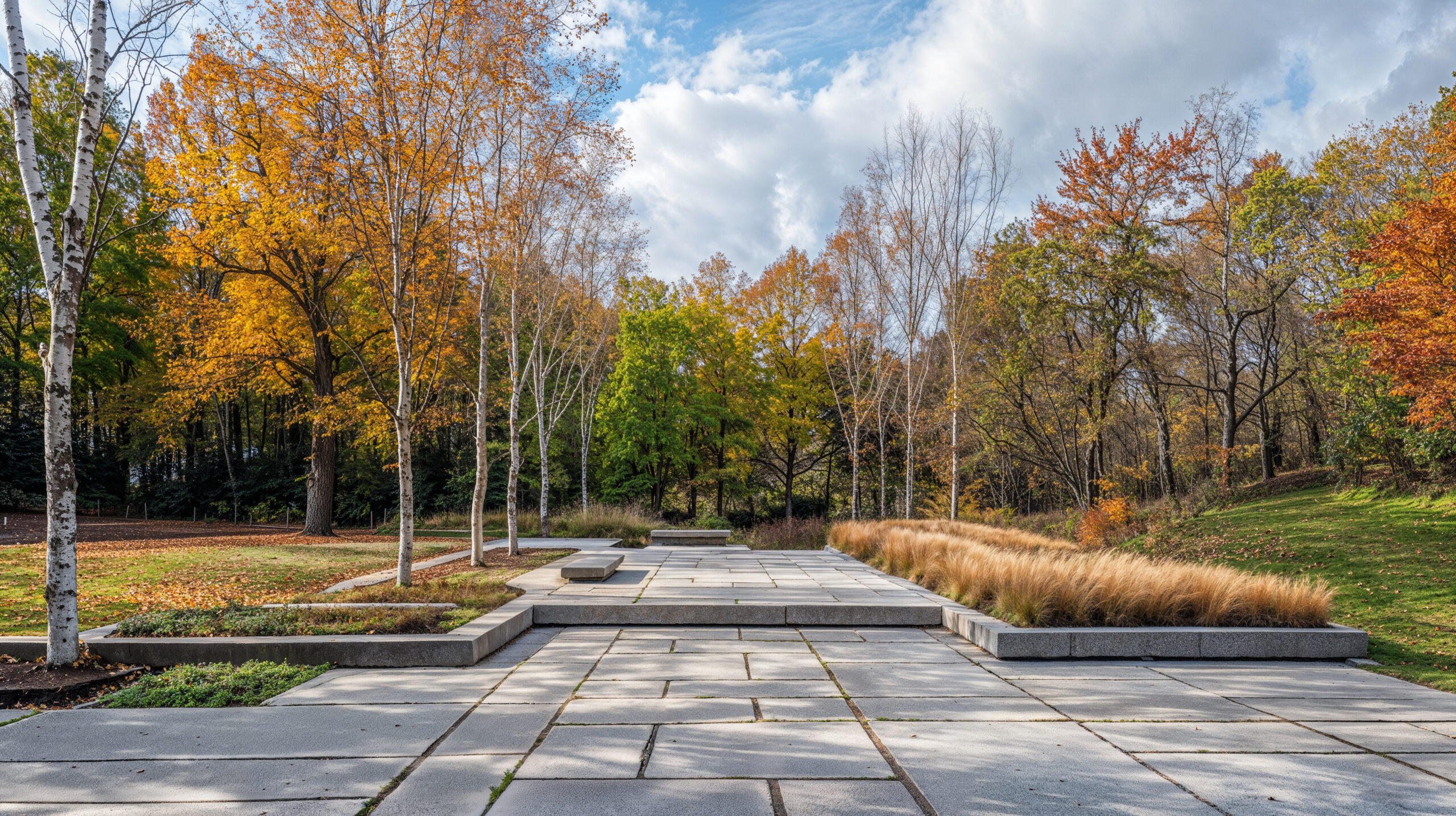 An image highlighting landscape architecture with a walkway made of pavers surrounded by grass and trees.