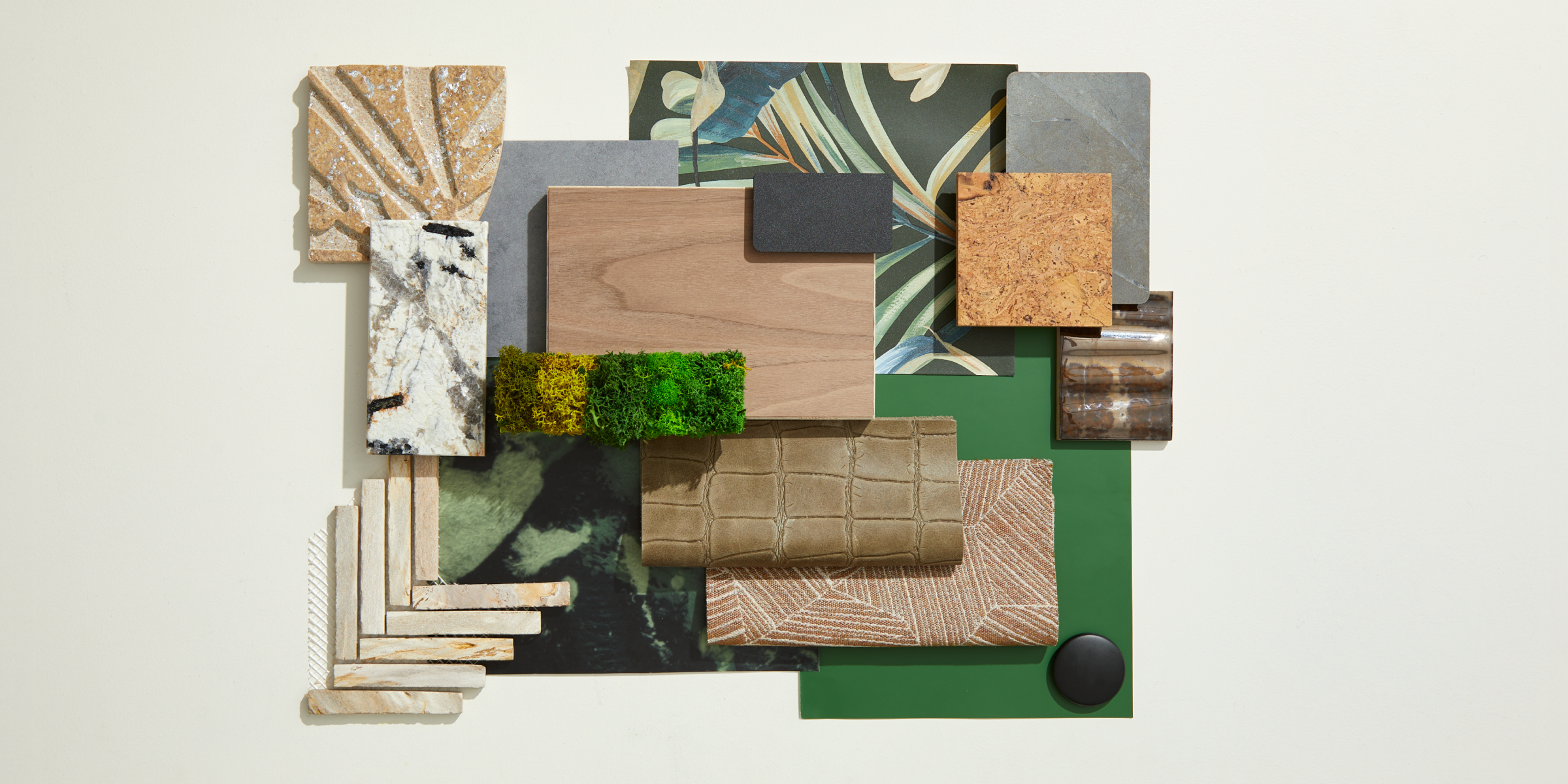 A flatlay photograph with botanical wallcoverings, bone colored tiles, and natural woods.