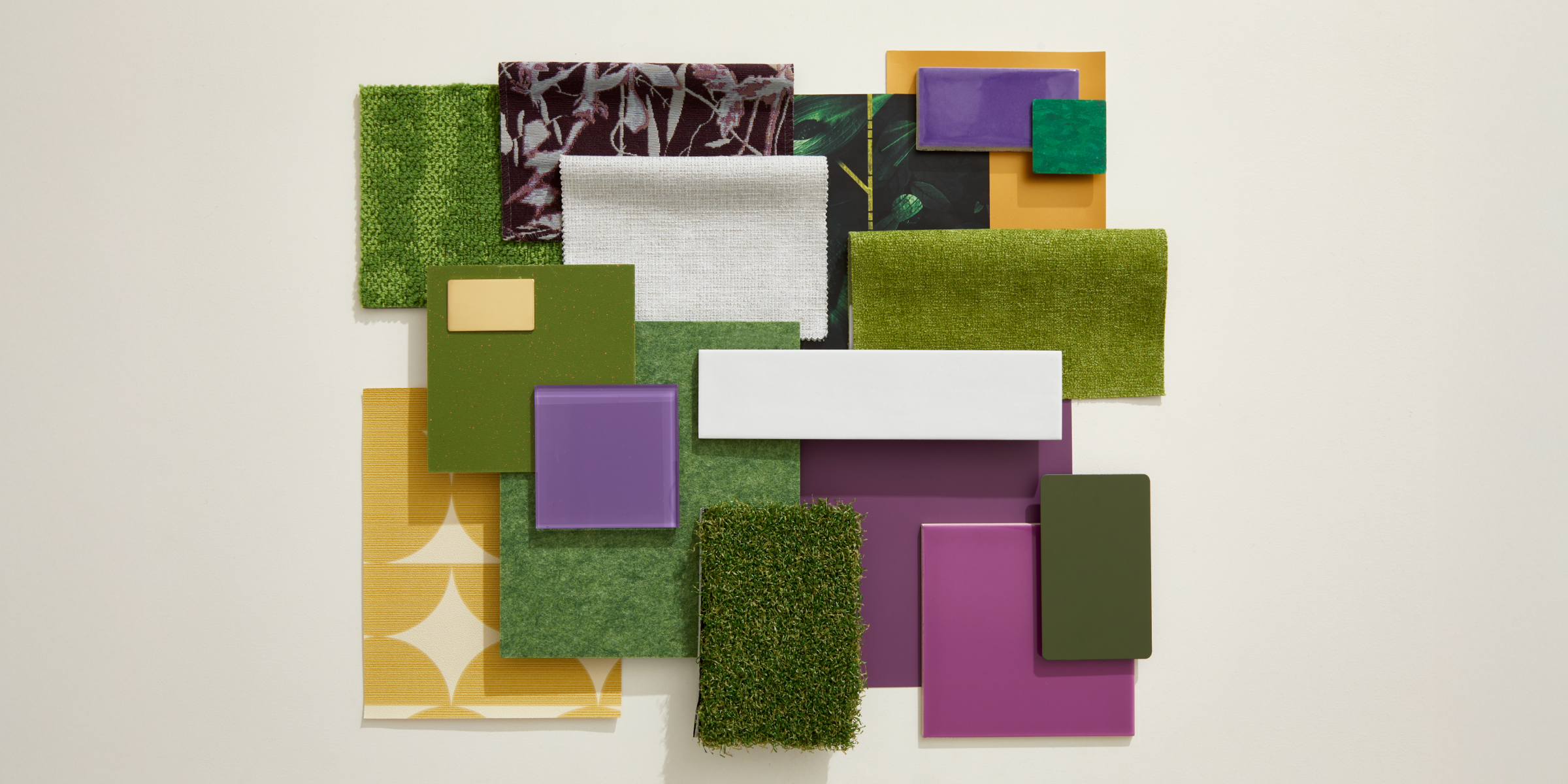 A flatlay photograph with green turf, purple tiles, and gold wallcoverings.