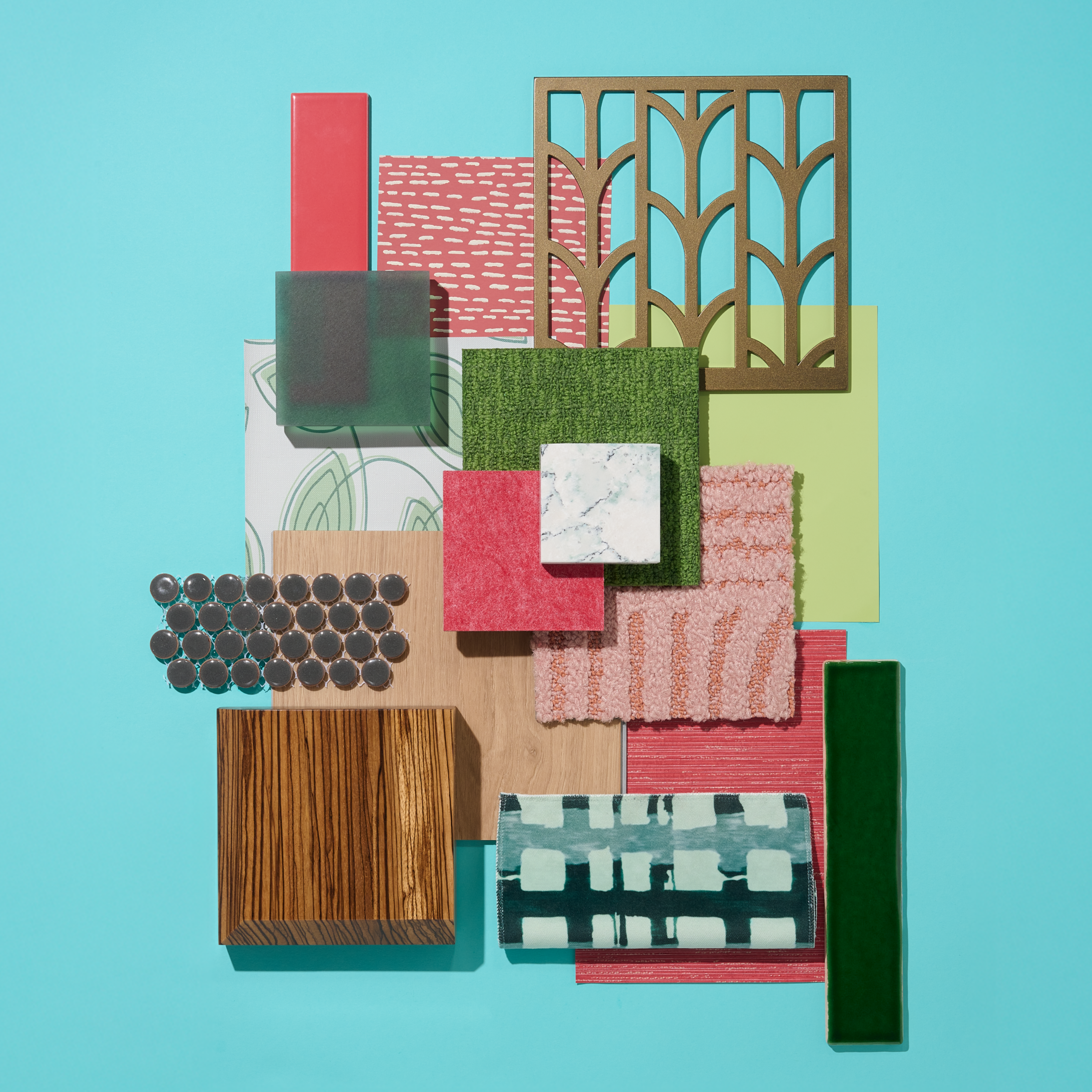 A flatlay photograph with warm woods, pink and green paint, and vibrant wallcoverings.