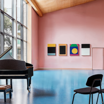 A postmodern music hall with blue flooring, large windows, and pop-art decor.