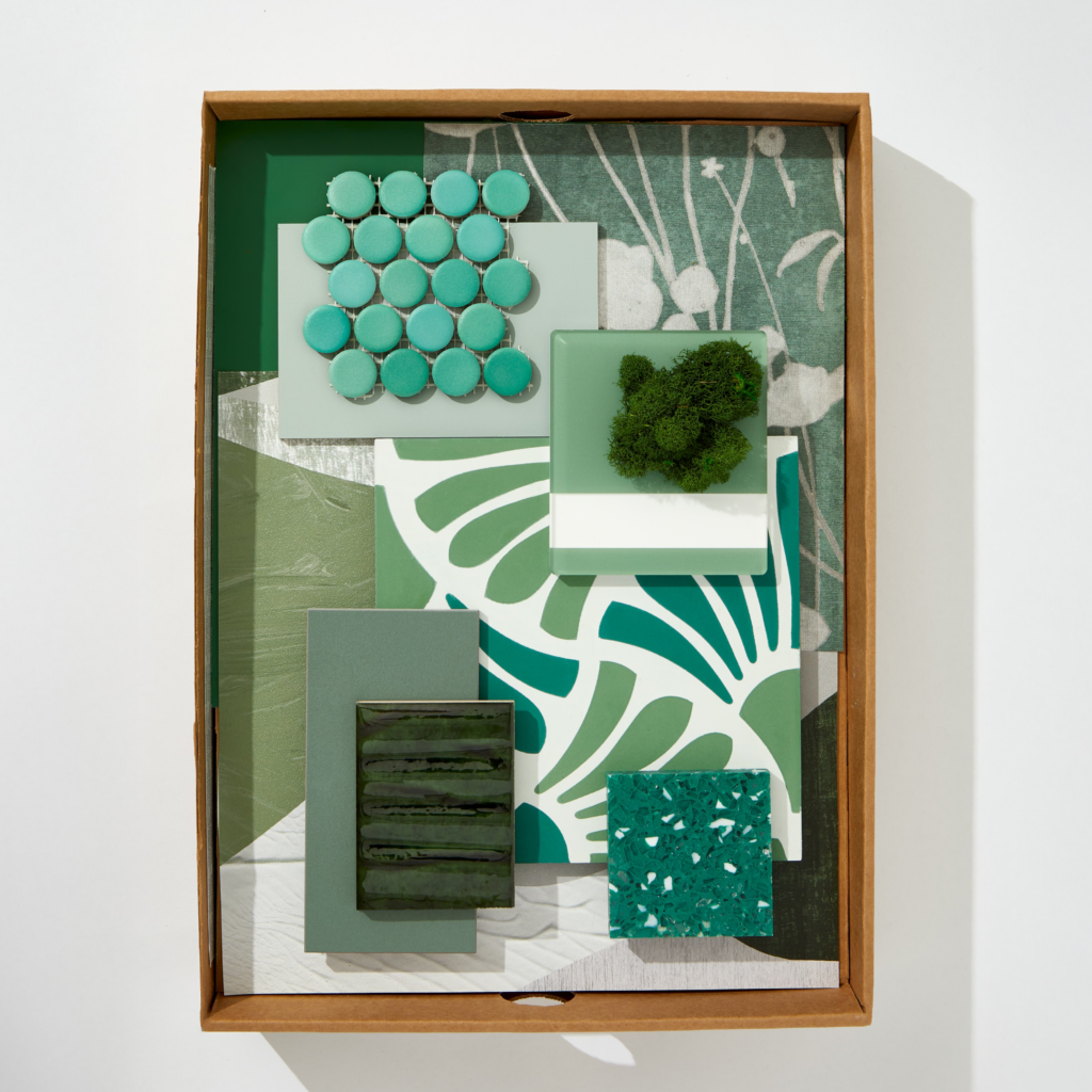 A flatlay image of boxed green textiles, stone, wallpaper, and materials.