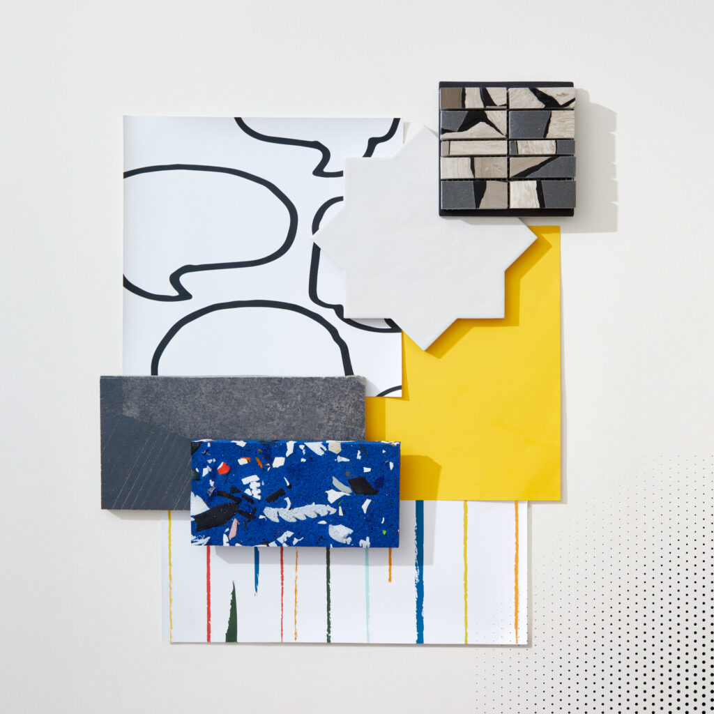 A flatlay photograph with yellow paint, comic inspired wallpaper, and geometric tiles.