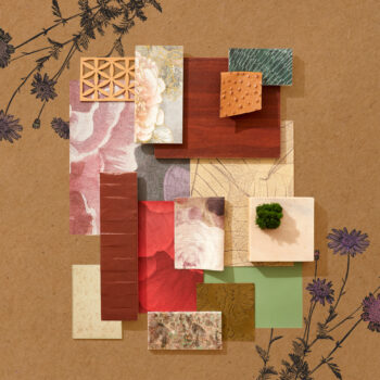 A flatlay photograph with floral patterned wallpaper, dark woods, and earth-toned fabrics.