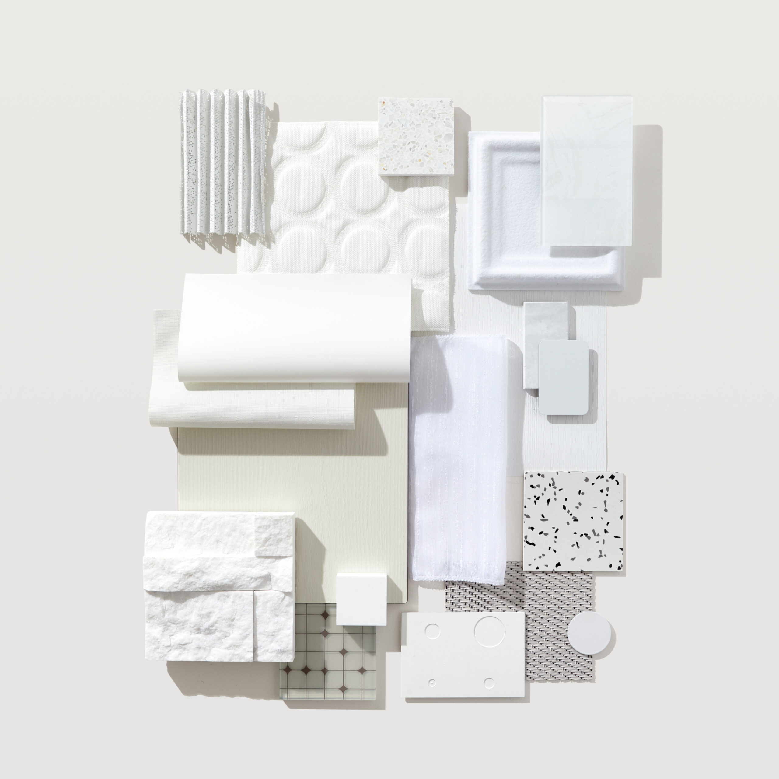 A flatlay photograph with posh textiles, bright tiles, and white woods.