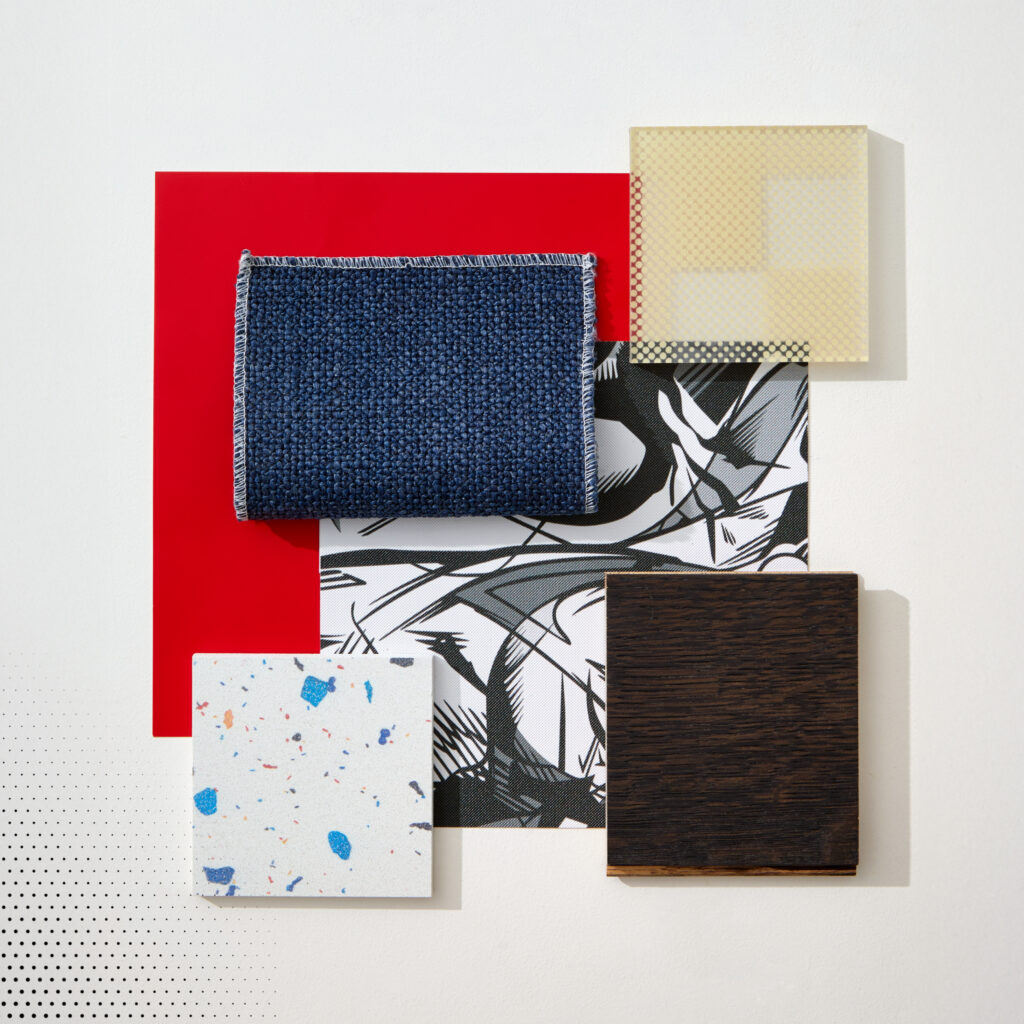A flatlay image with red paint, blue textiles, and color splattered tile.