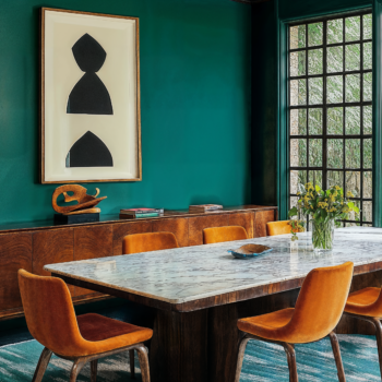 A formal dining room with upholstered chairs, granite dining table, and patterned broadloom carpet.