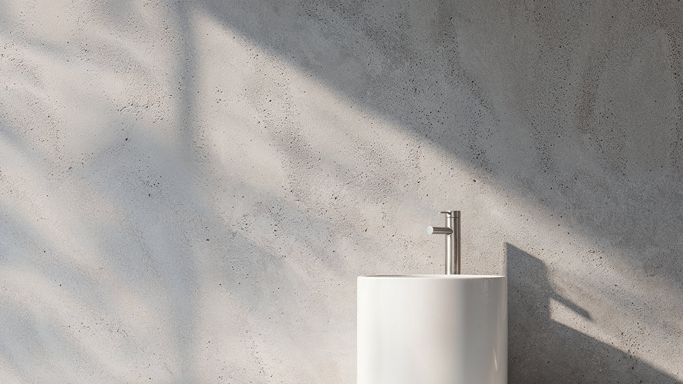 Minimalist bathroom with an off-white sculptural sink and concrete wall, natural lighting casting soft shadows on the wall and creating a tranquil atmosphere.