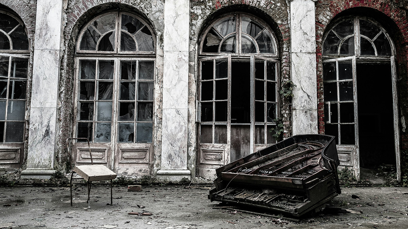 An abandoned palace with broken windows and a destroyed grand piano in the foreground.