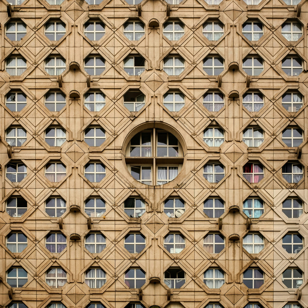 A closeup detail shot of a facade made of hexagonal windows with rounded corners, symmetrical grid pattern.