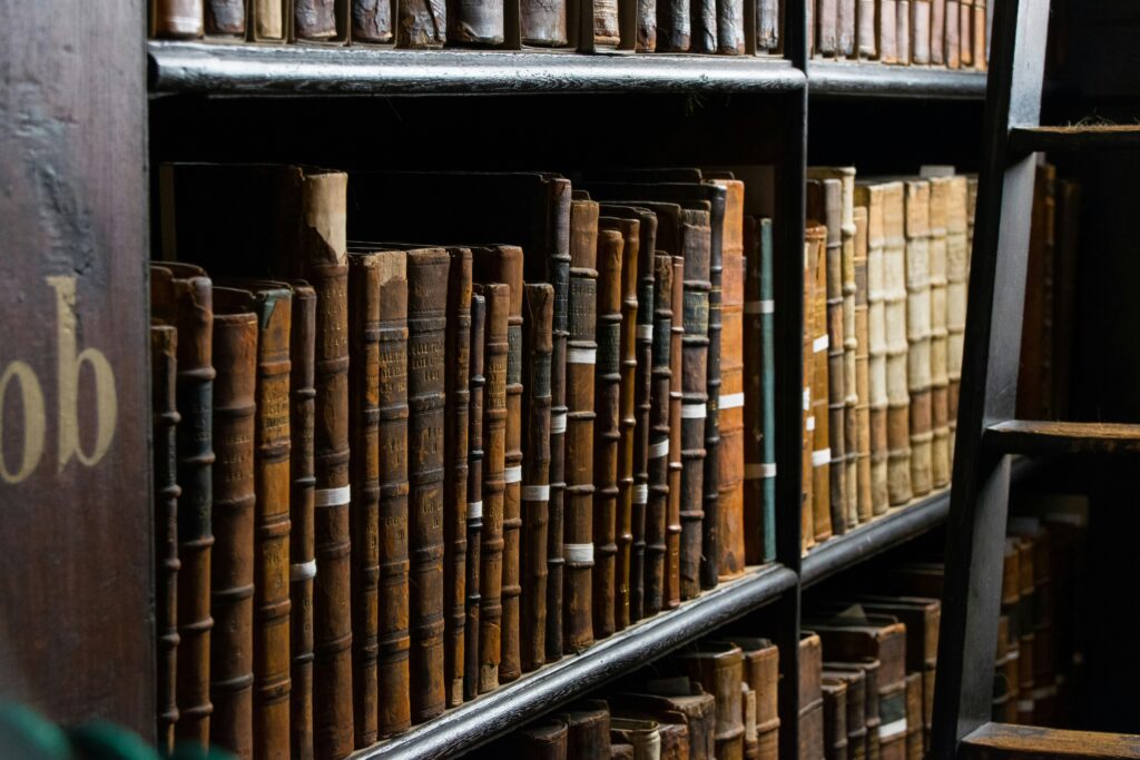 A close up shot of books on bookshelf near a ladder at the Library of Trinity College in Dublin, Ireland. 