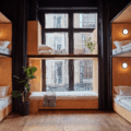 A modern dormitory with wooden wall paneling, black curtains, and warm lighting.