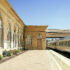 A French provencal designed train station with limestone walls, wooden doors, and brick walkways.
