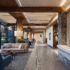 Argentinian Estancia Design healthcare lobby with stone detail, wooden beams, large windows, neutral palette.