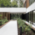 Exterior of a building that is a biophilic healing space with wood paneling along the side of the building. Large floor to ceiling windows allow for views of the surrounding landscape to bring the green space in.