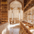 A Moroccan design tea shop with stone floors, intricate detailed design, and archways throughout the space. Shelves filled with various teas and design in neutral colors of beige, cream and golds.