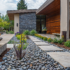 Designing for water conservation with a landscape featuring plants and succulents, a bed of rocks, stone pavement, and a fountain of water.